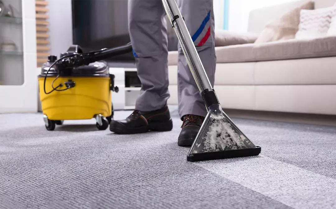 Technician deep cleaning a light carpet with a hot water extraction machine, Buffalo Carpet NY