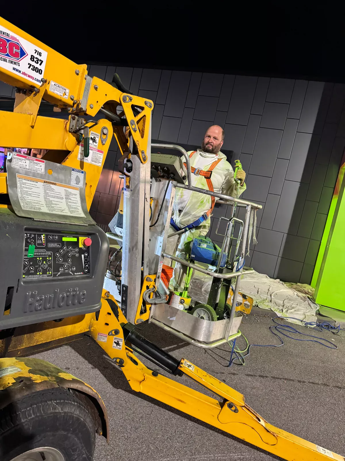 Crew member on a lift during a night painting job, Buffalo Carpet NY